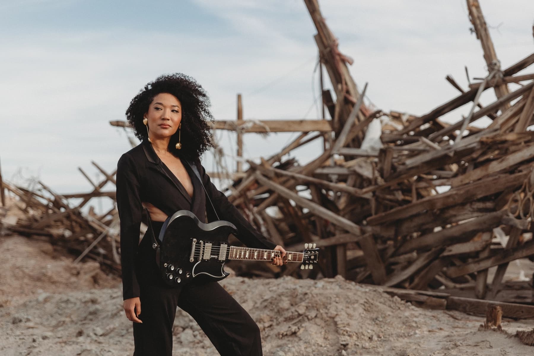Judith Hill standing in front of a pile of wood