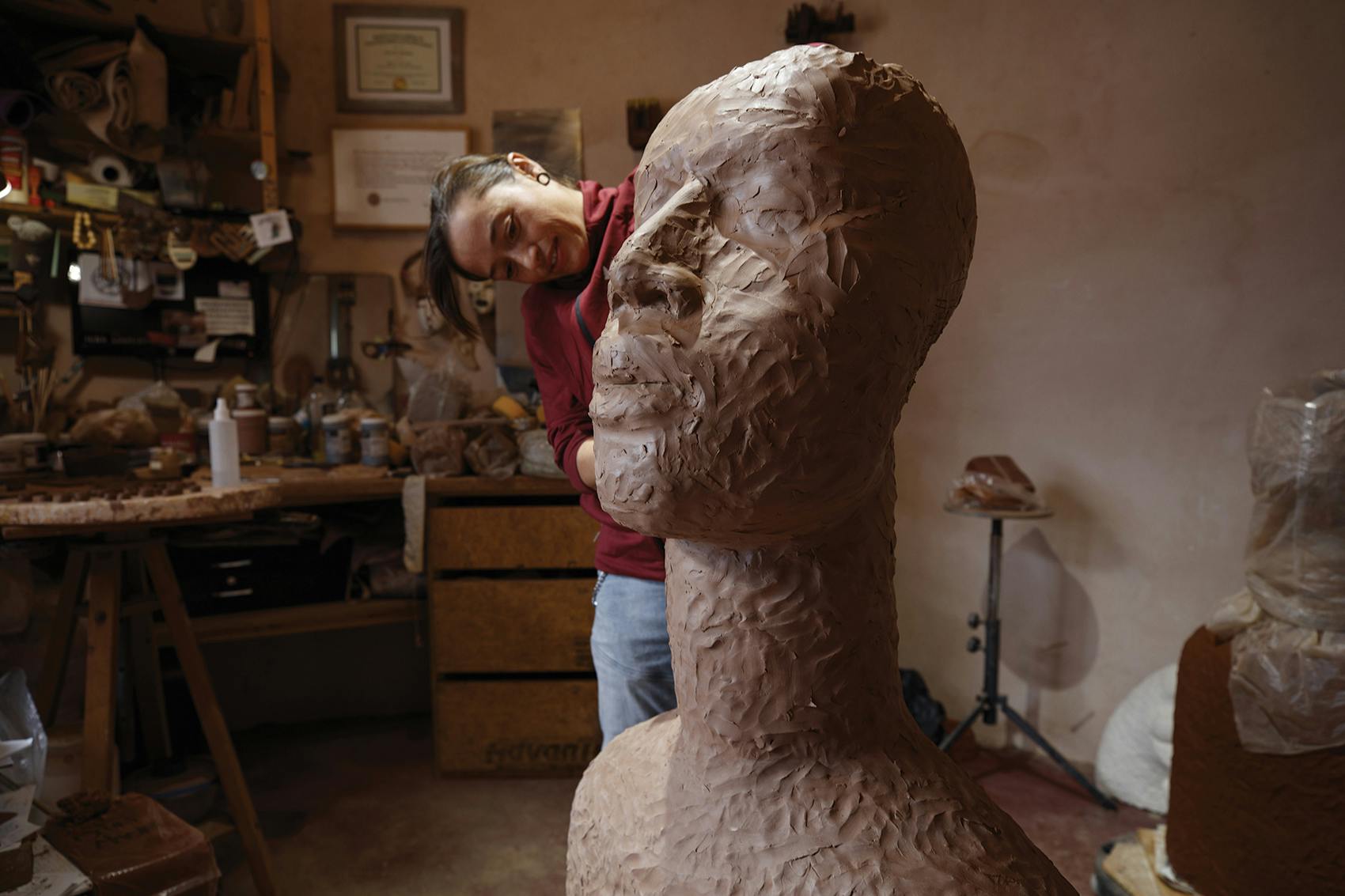 person carving a large brown statue