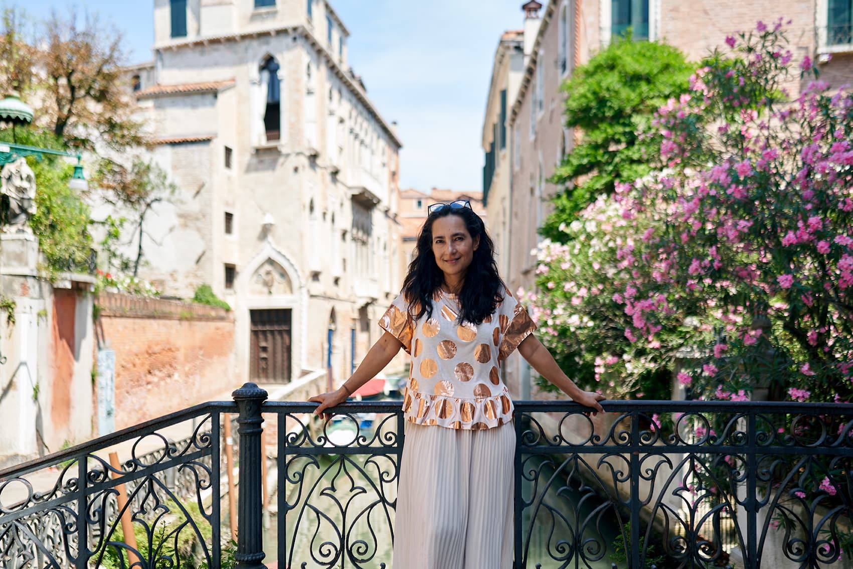 Woman posing in front of a canal in Venice, Italy.