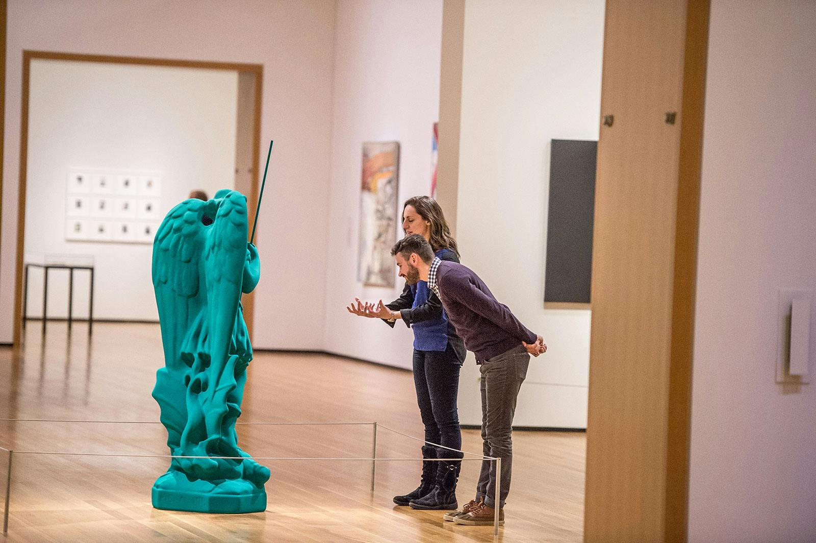 visitors looking at a green sculpture in galleries