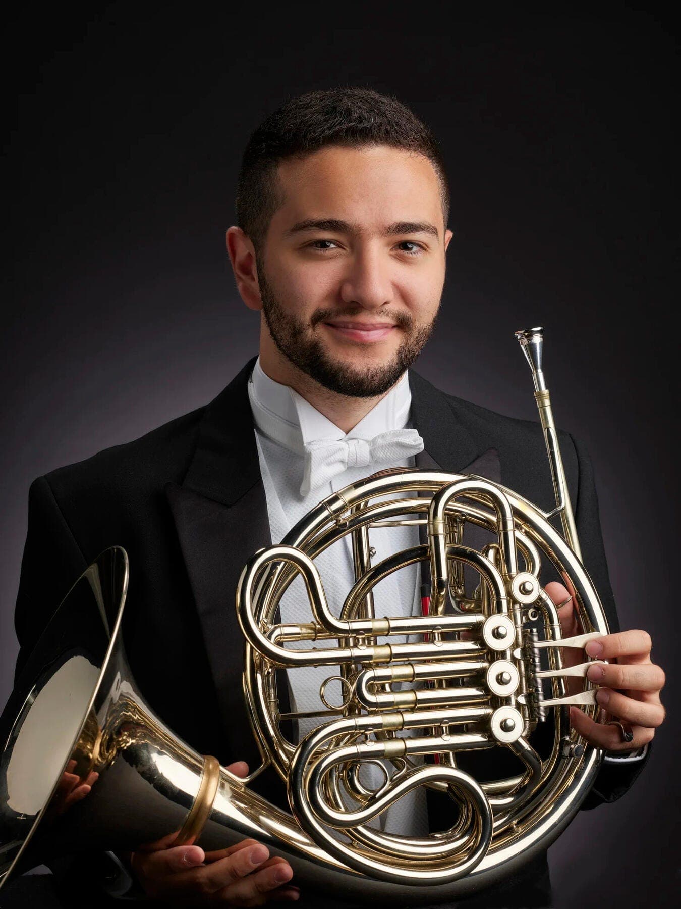 a man holding a large brass instrument