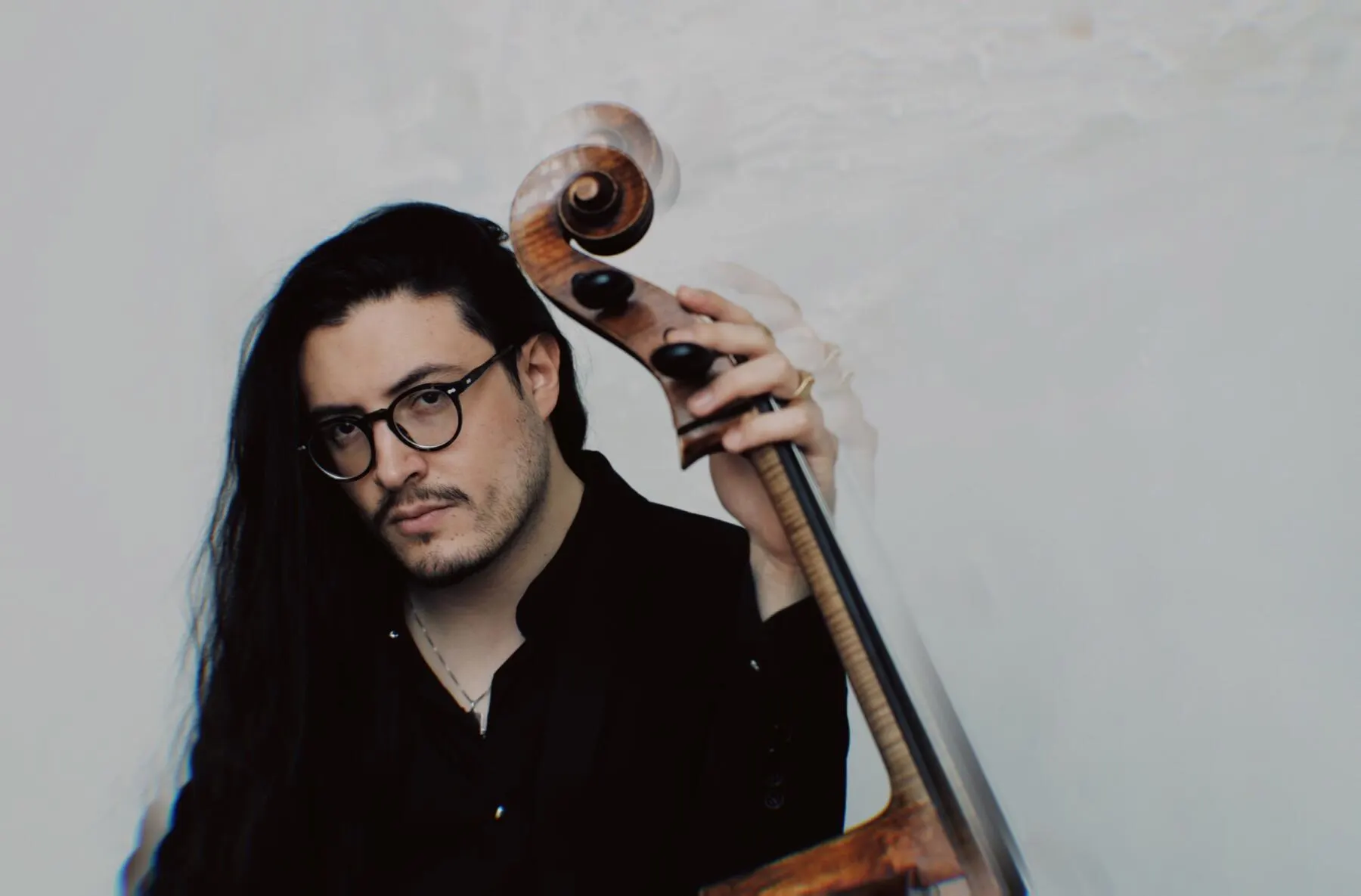 a person with long hair and glasses holding a gun