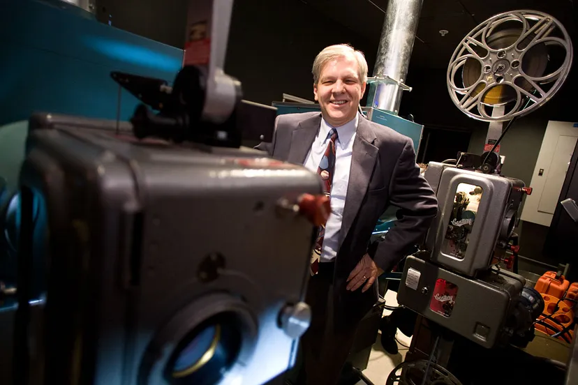 Photograph of a man surrounded by film equipment.